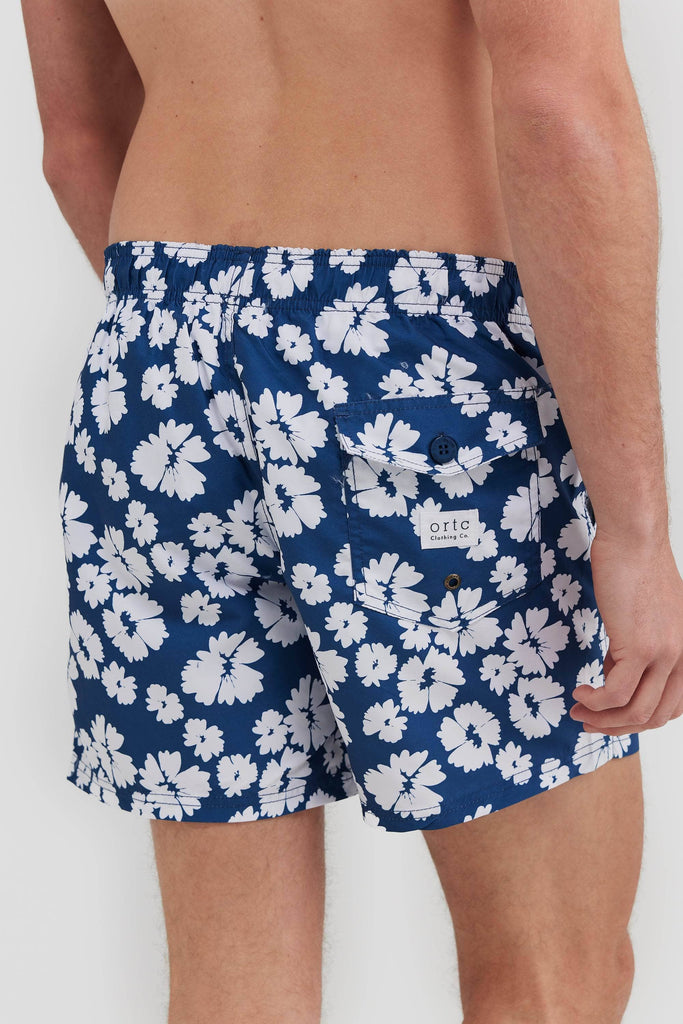 Men's board shorts.Blue with white flowers. Showing back pocket with ortc logo.