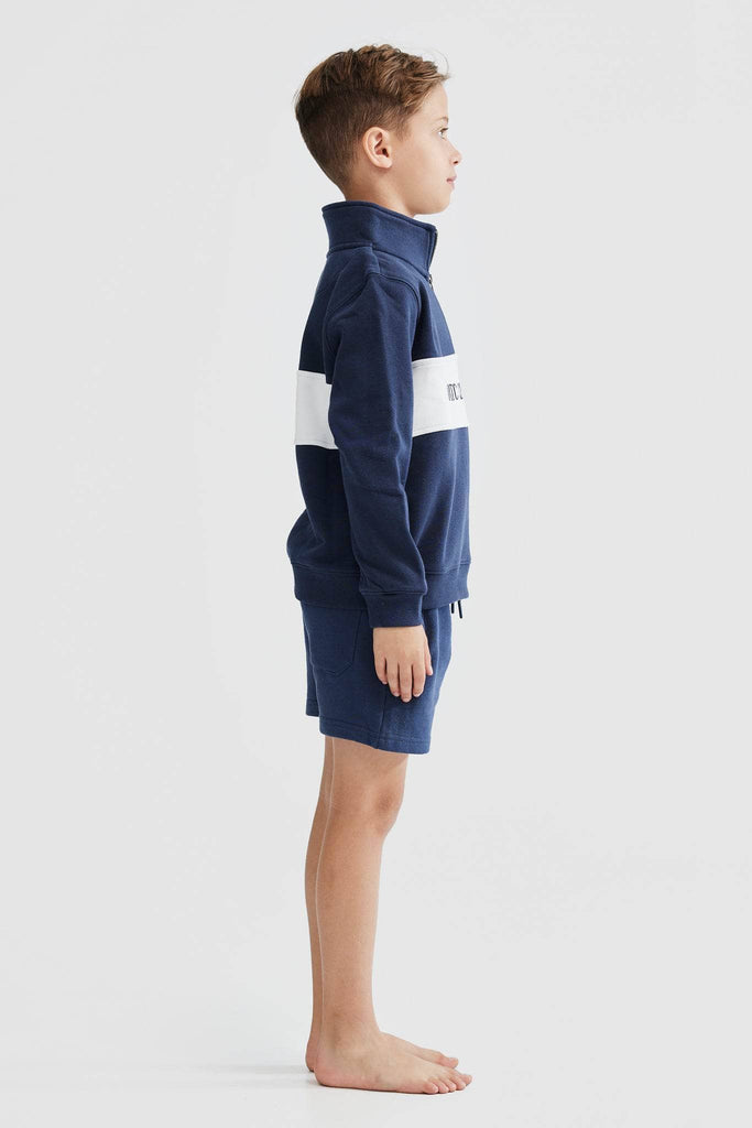 Child model wearing navy quarter zip with with white middle panel with navy ortc embroidered clothing co
