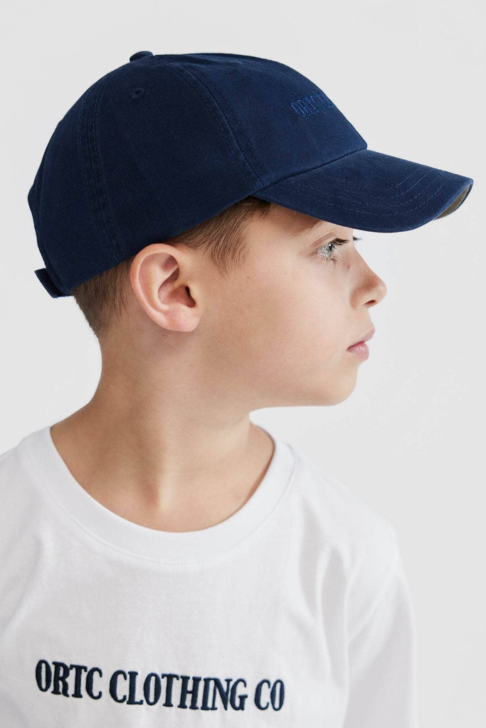 Side view of child wearing navy baseball cap