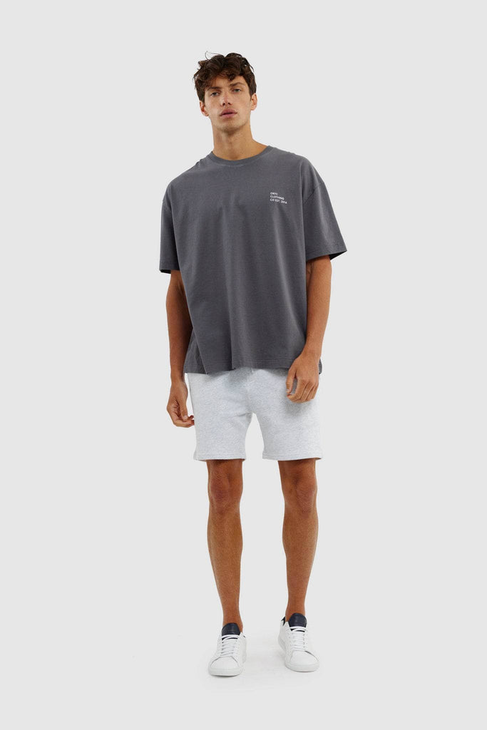 Full length view of model wearing boxy charcoal tshirt with white lounge shorts and sneakers